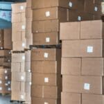 warehouse pallets stacked with packaging cartons showing high inventory levels in distribution center