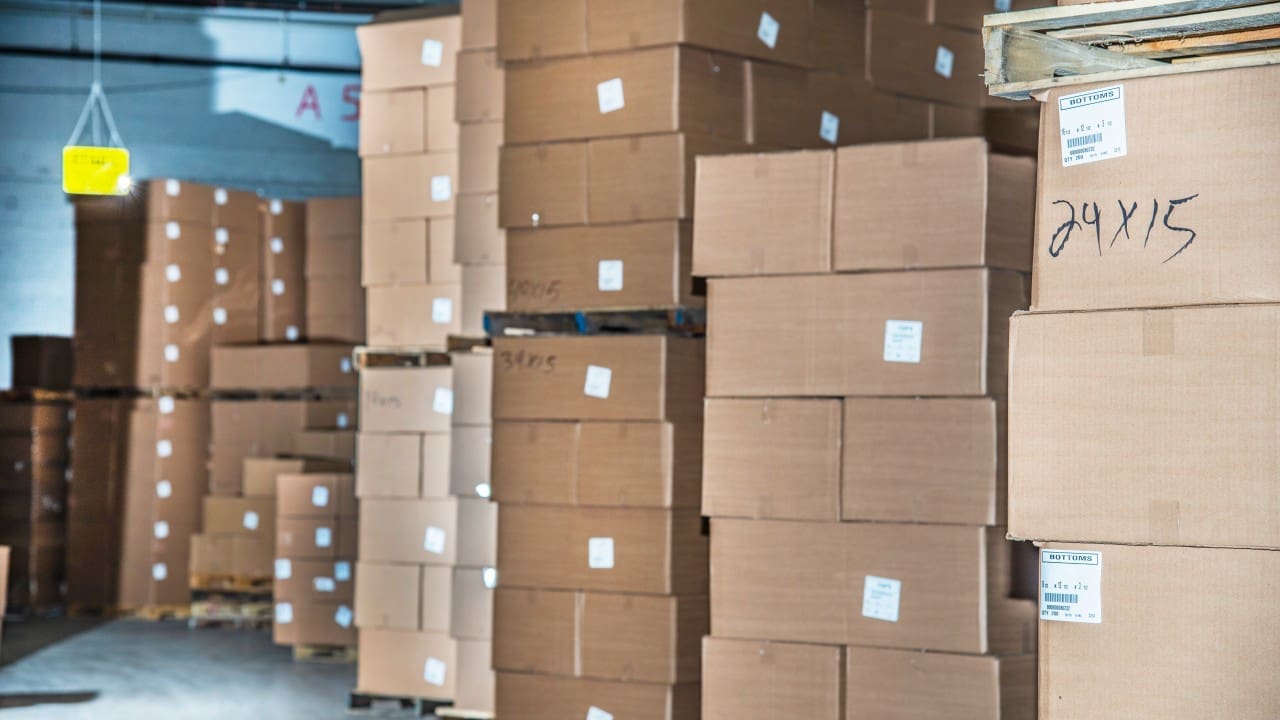 warehouse pallets stacked with packaging cartons showing high inventory levels in distribution center